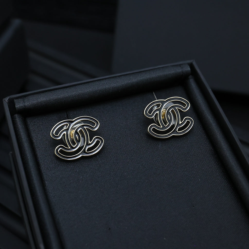 CC logo stud earrings in a black jewelry box, silver-toned with black enamel