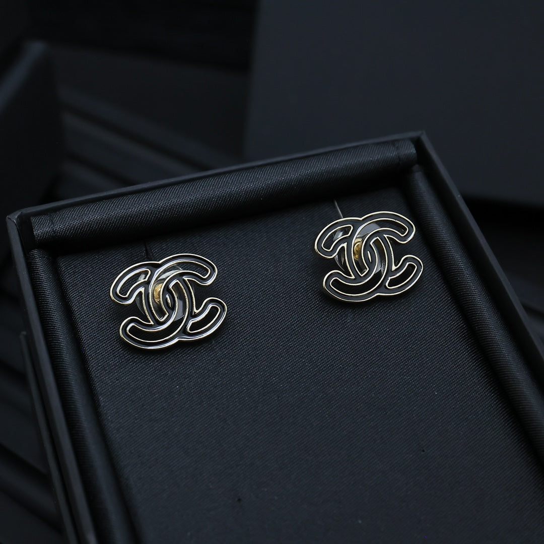 CC logo stud earrings in a black jewelry box, silver-toned with black enamel