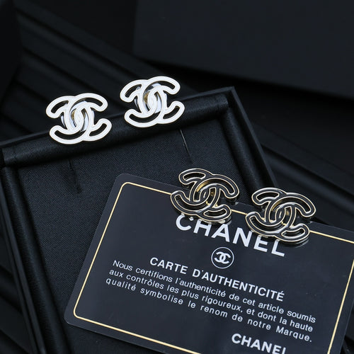 CC logo stud earrings with silver-toned outlines on a black accessory box