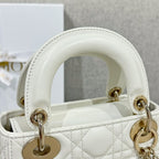 White Dior handbag top handle with gold-tone rings and stitched leather