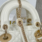 White Dior handbag close-up of interior top with gold-tone rings and chain strap