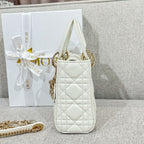 White quilted Dior mini handbag with top handles and gold-tone charm, side angle