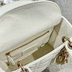 White Dior handbag interior with zipper pocket and gold-tone zipper pull, close-up