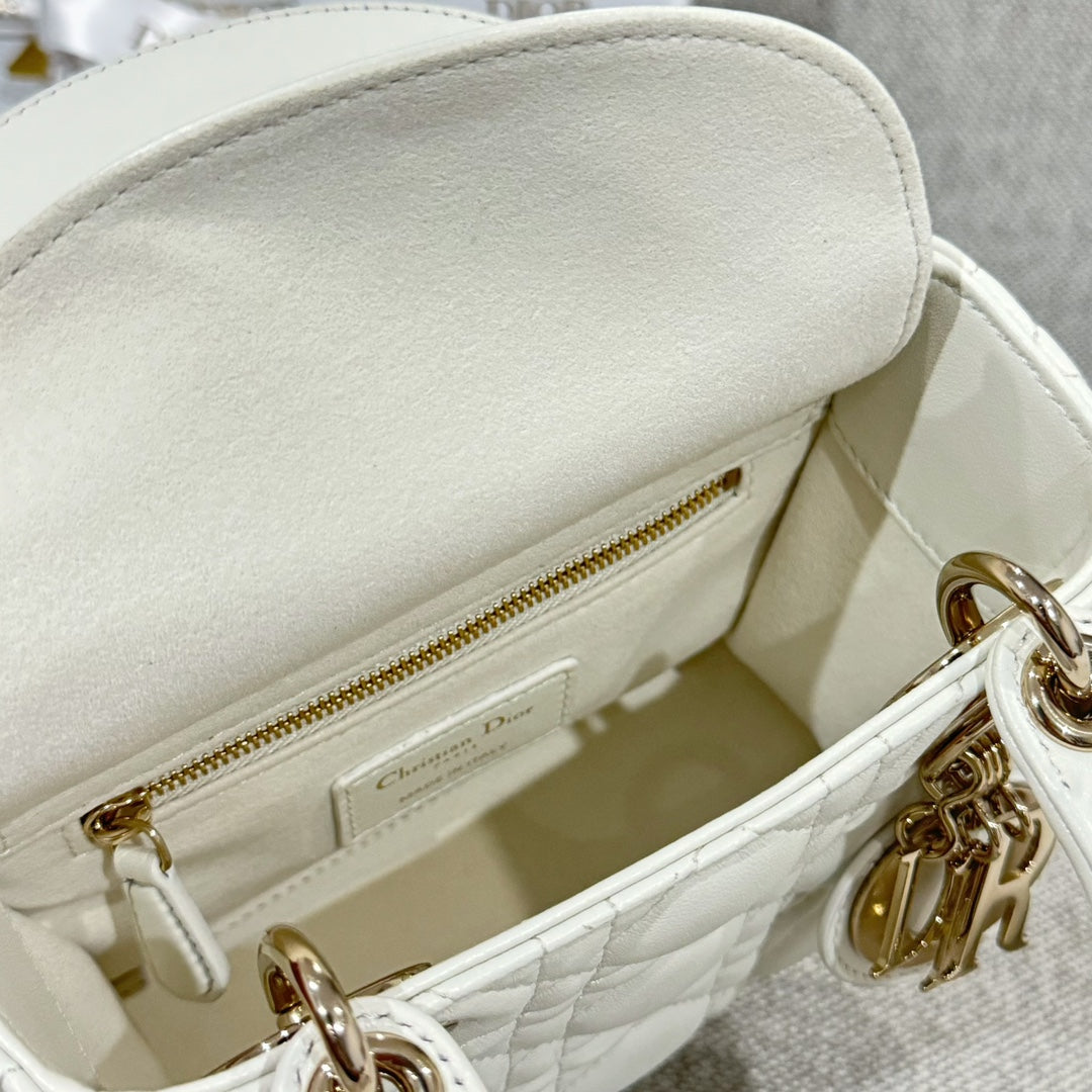 White Dior handbag interior with zipper pocket and gold-tone zipper pull, close-up