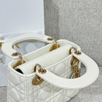 White quilted Dior handbag open top showing interior and gold-tone handle rings