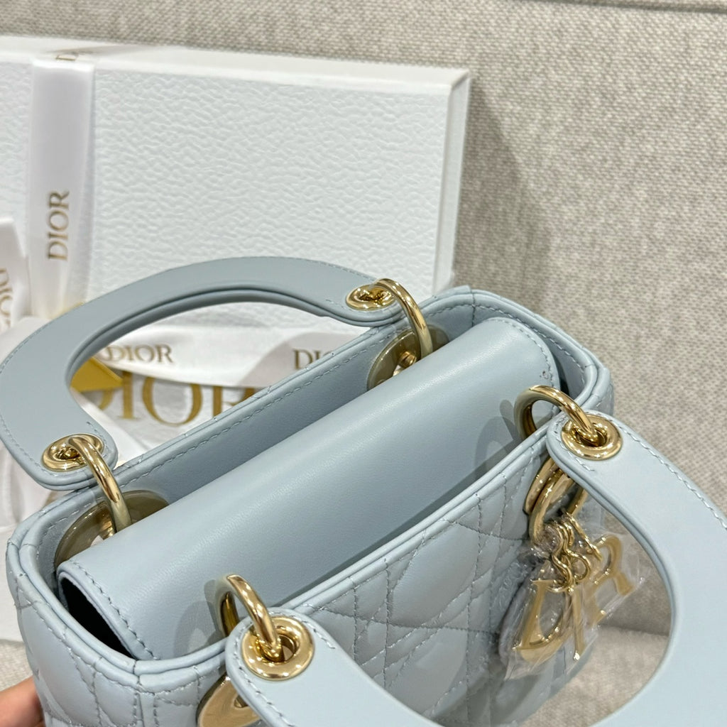 Light blue quilted handbag with open top, gold-tone rings, and inner logo lining