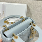 Light blue quilted handbag with open top, gold-tone rings, and inner logo lining