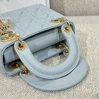 Light blue quilted handbag with open top and gold-tone rings on side handles