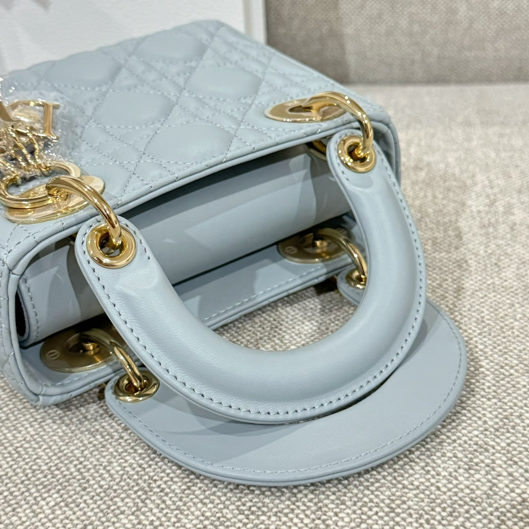 Light blue quilted handbag with open top and gold-tone rings on side handles