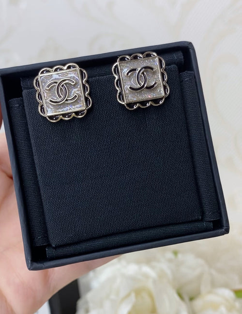Stud earrings with silver square frames and Chanel logo centers