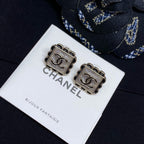 Square stud earrings with silver Chanel logo plaques and scalloped borders