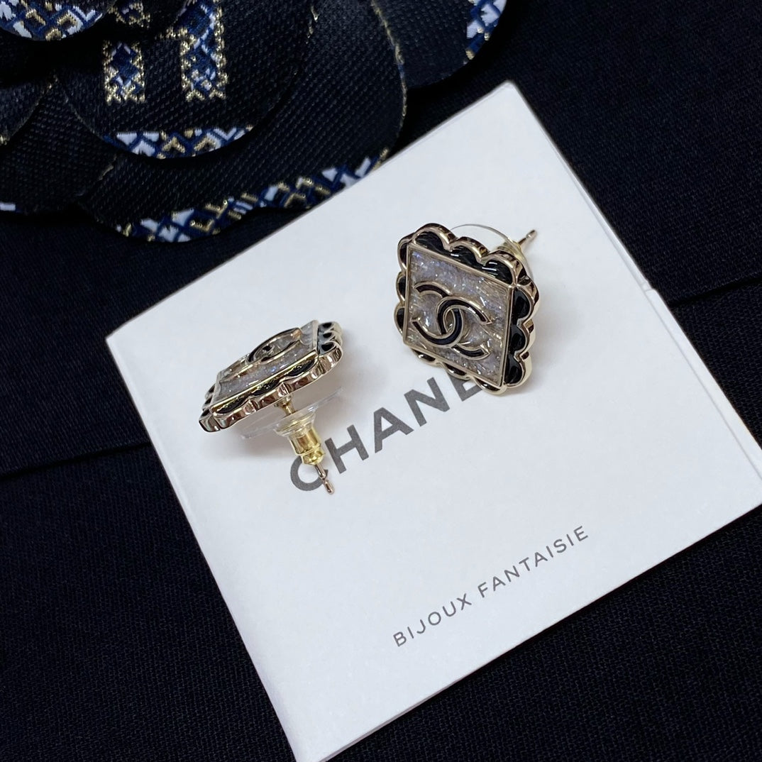 Gold-tone square stud earrings with Chanel logo, on display card