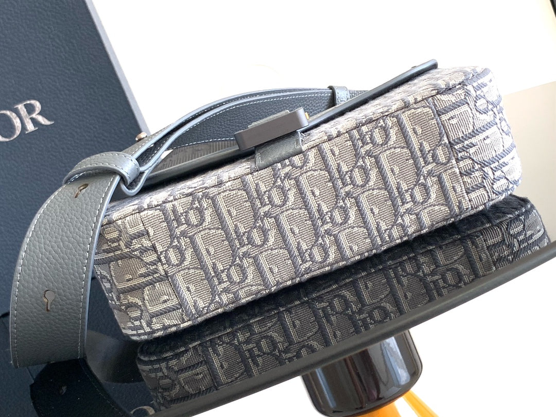 Dior crossbody bag top view with metal strap ring and Dior Oblique canvas exterior.