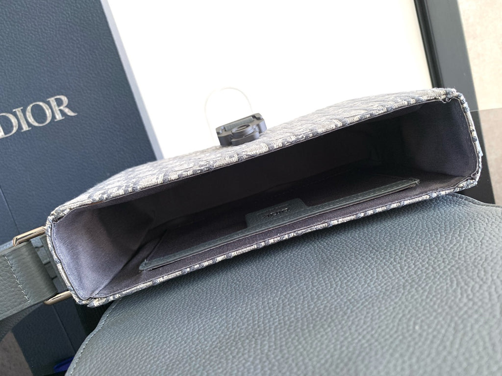 Dior crossbody bag open view, showing interior and gray leather flap edge.