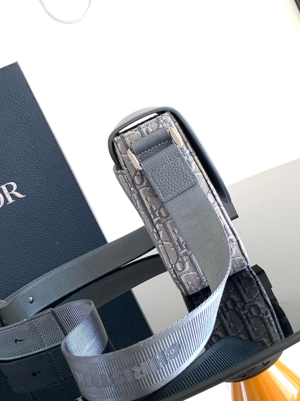 Dior crossbody bag rolled strap detail, showing Dior Oblique canvas lining and hardware.