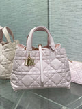 Dior handbag in light pink quilted leather with top handles and gold logo charm