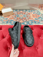 Black Louis Vuitton monogram slide sandals, front view with buckle strap and faux-fur