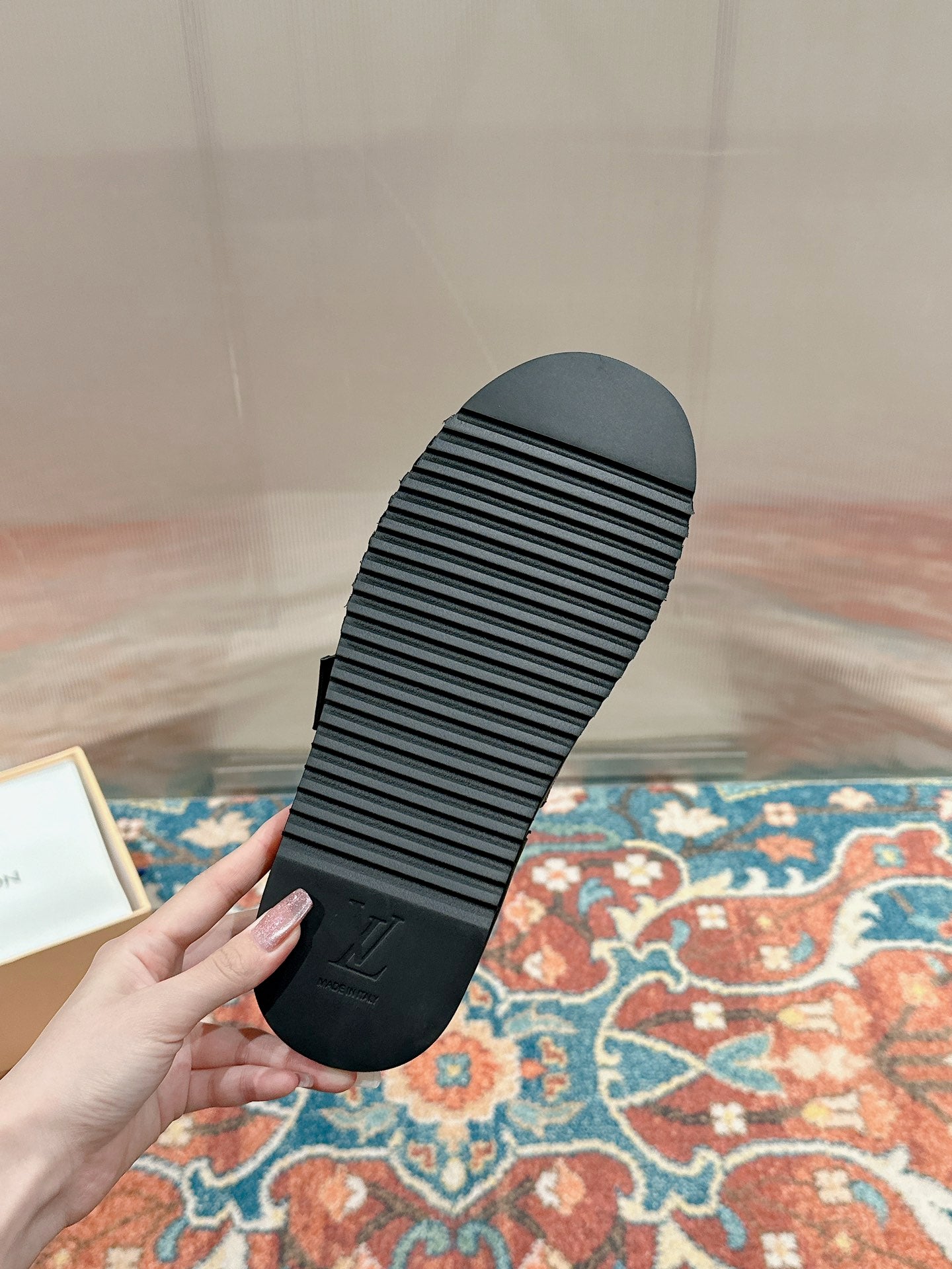 Black rubber outsole of a Louis Vuitton slide sandal with ridged tread and logo