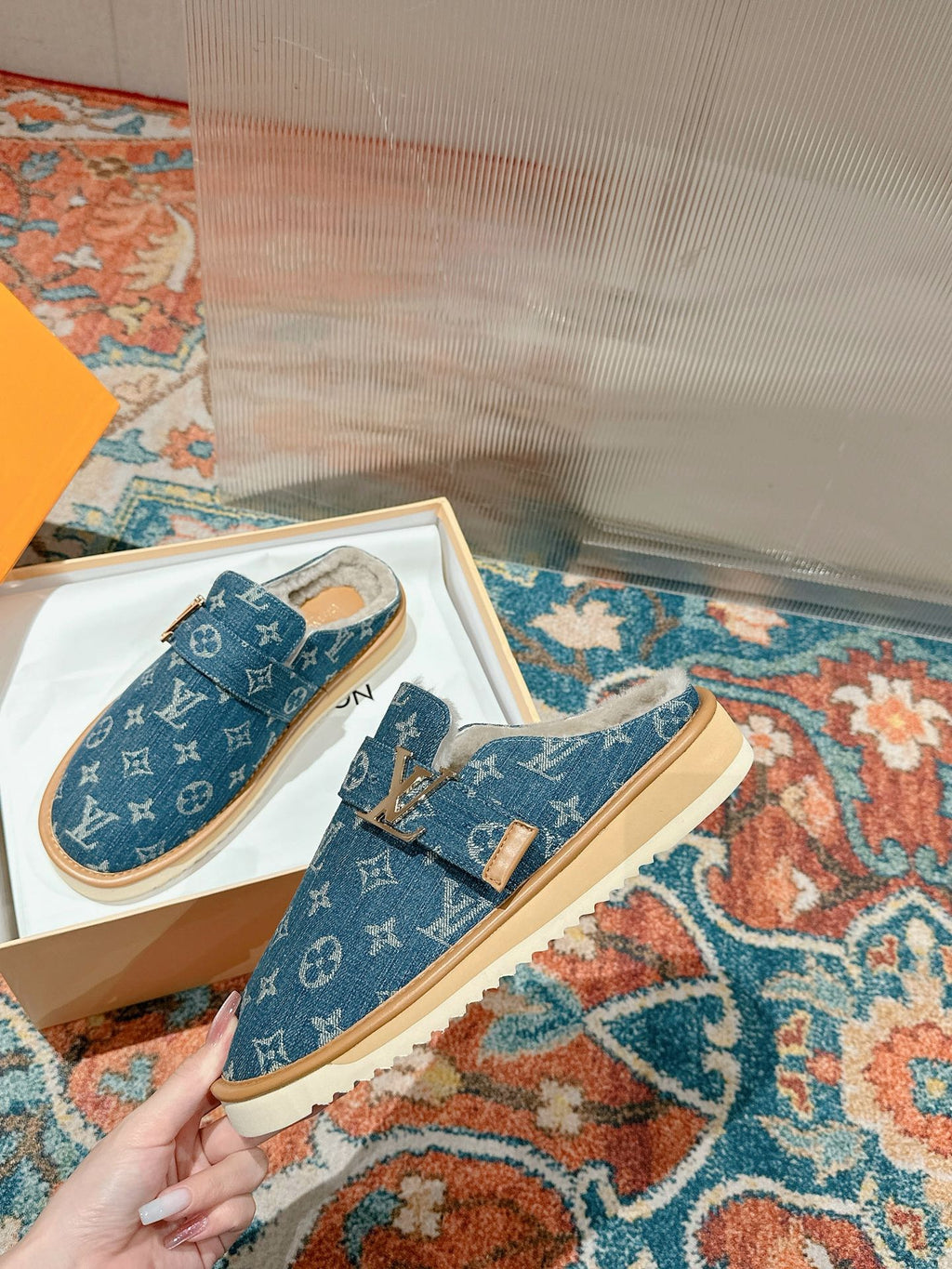 Blue Louis Vuitton monogram slide sandals with tan soles and top buckle strap detail.