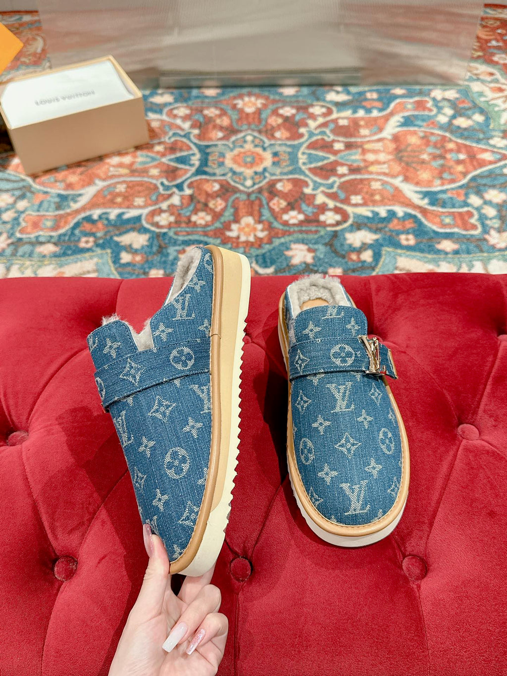 Pair of blue Louis Vuitton monogram slide sandals with tan soles and fur lining.