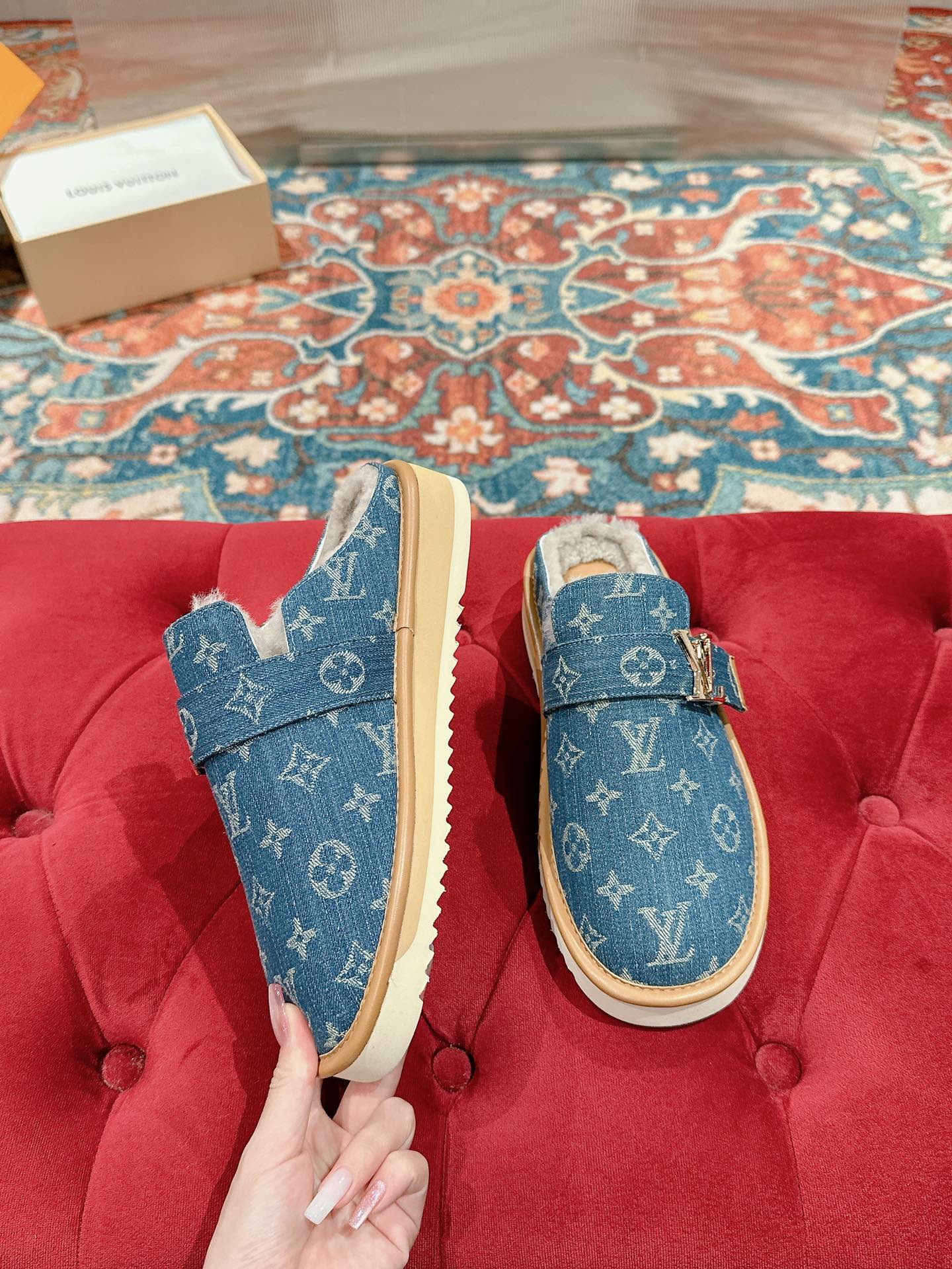 Pair of blue Louis Vuitton monogram slide sandals with tan soles and fur lining.