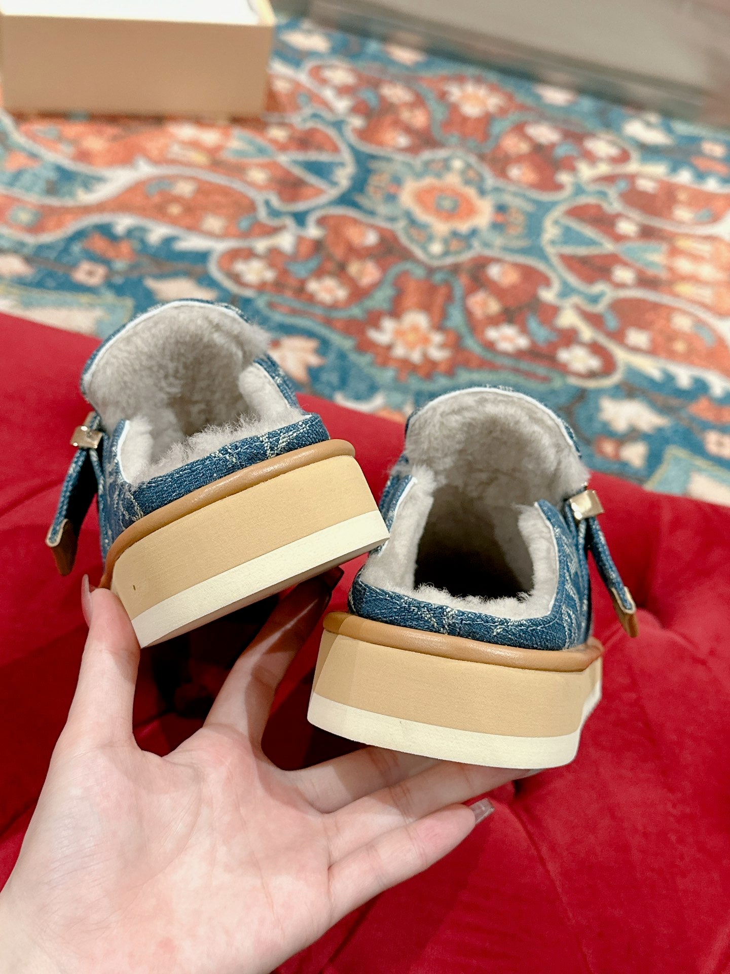 Blue Louis Vuitton monogram slide sandals from the back, fur lining and tan sole.