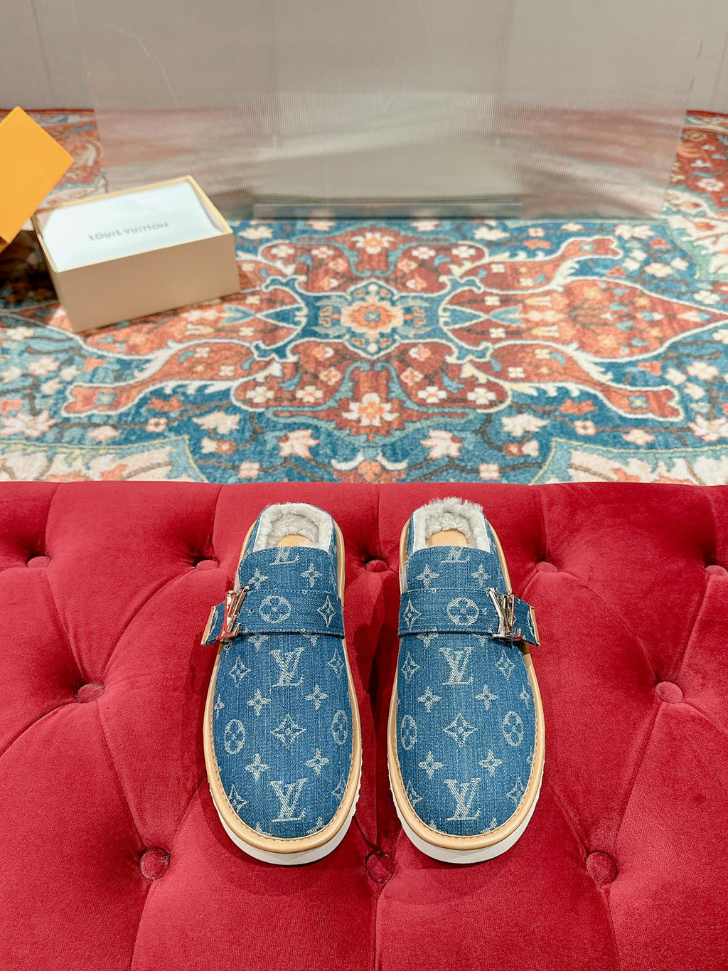 Blue Louis Vuitton monogram slide sandals with tan rubber sole and fur-lined interior.