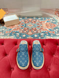 Blue Louis Vuitton monogram slide sandals with tan rubber sole and fur-lined interior.