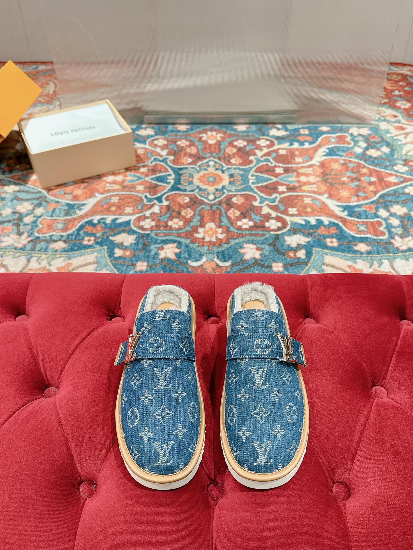 Blue Louis Vuitton monogram slide sandals with tan rubber sole and fur-lined interior.