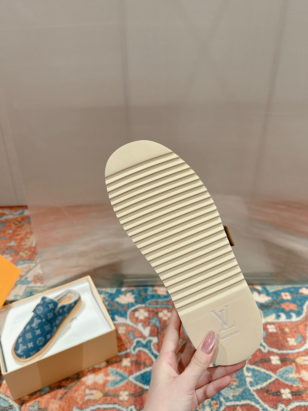 Tan outsole of blue Louis Vuitton slide sandal with ribbed traction pattern.