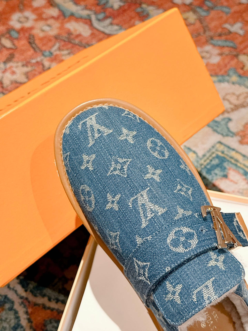 Blue Louis Vuitton monogram slide sandal with top strap and tan midsole, fur interior.