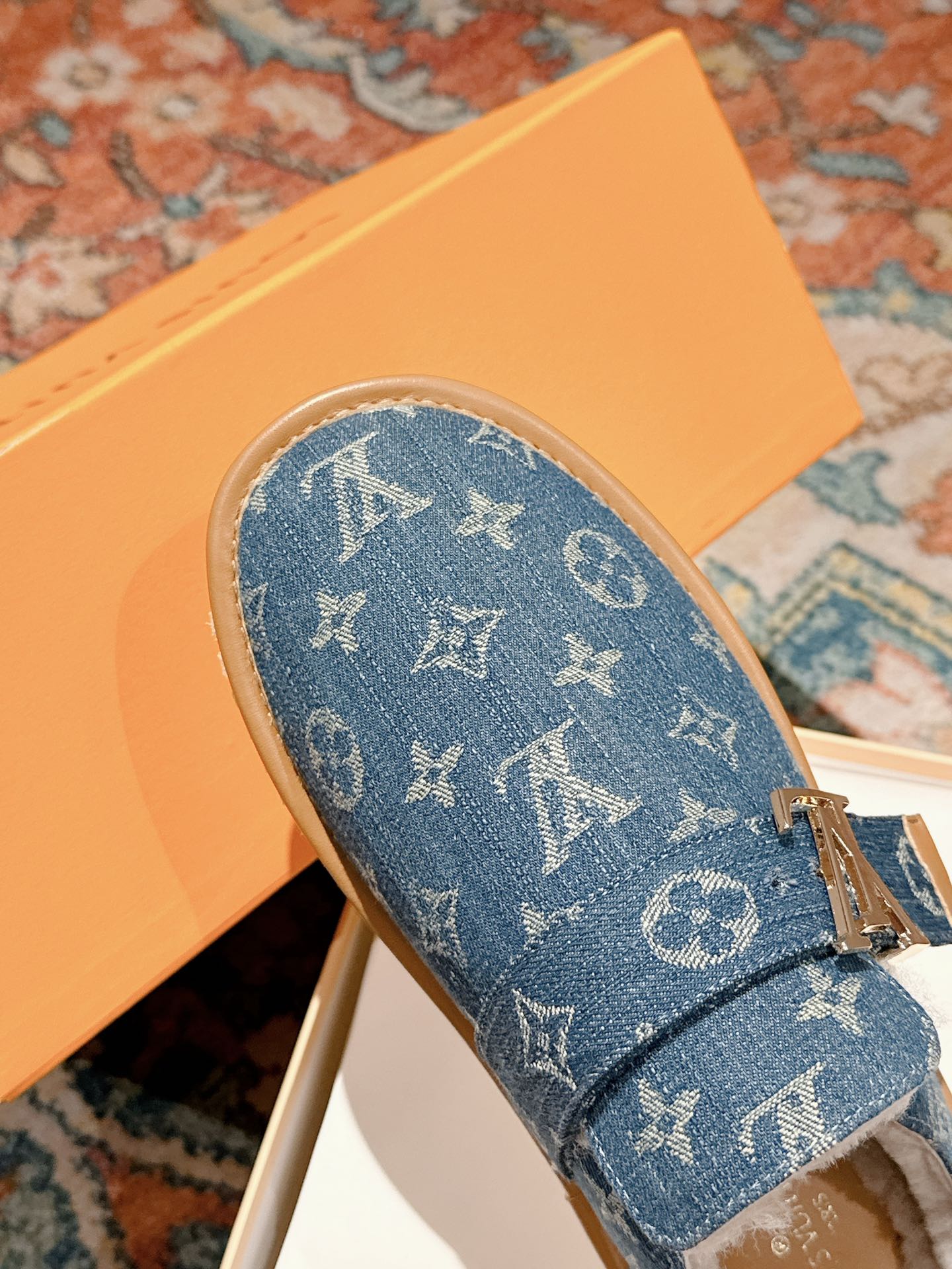 Blue Louis Vuitton monogram slide sandal with top strap and tan midsole, fur interior.