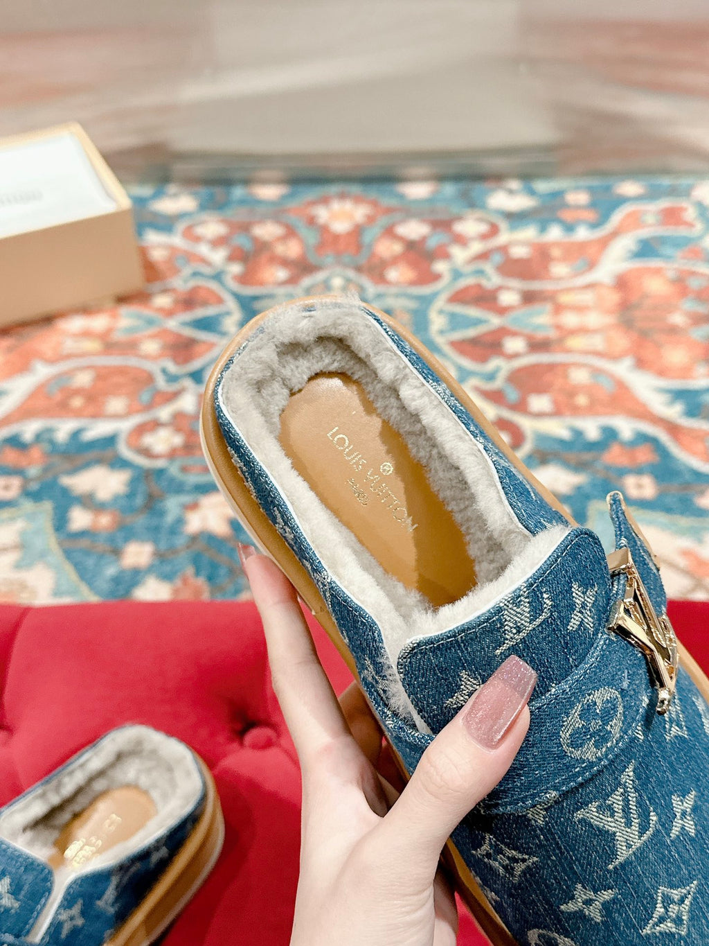 Blue Louis Vuitton monogram slide sandal showing fur-lined interior and front strap.