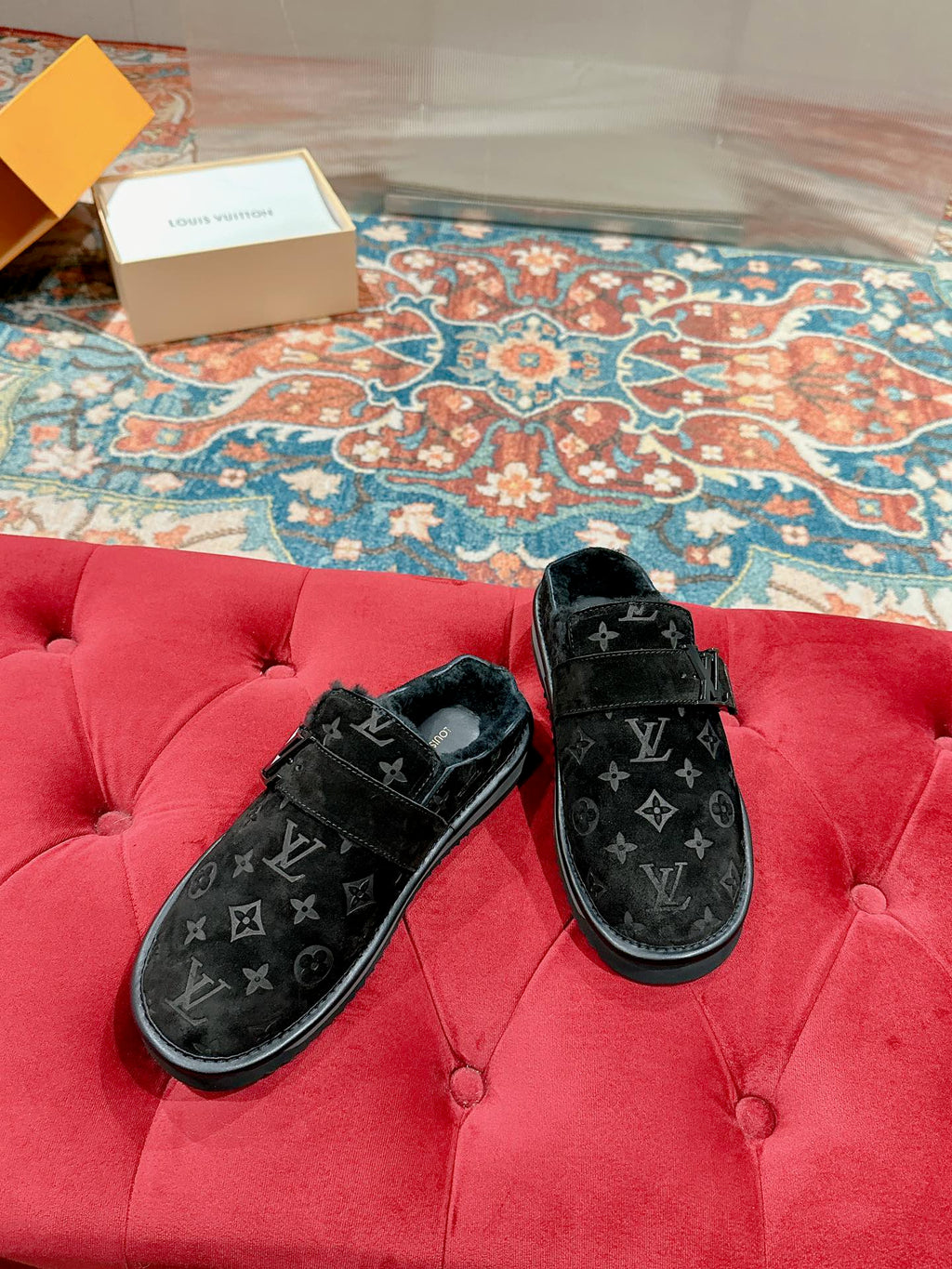 Louis Vuitton black velvet monogram sandals on a red tufted bench