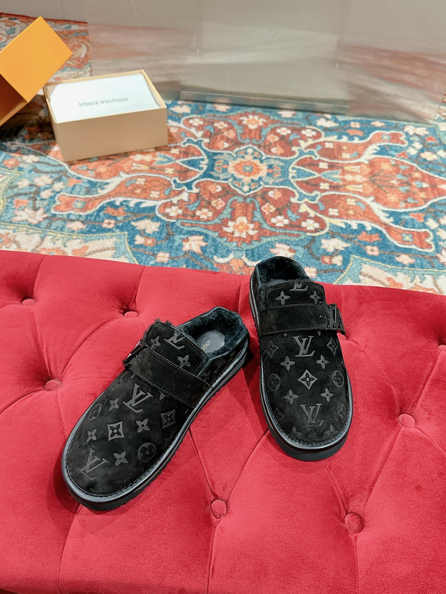 Louis Vuitton black velvet monogram sandals on a red tufted bench