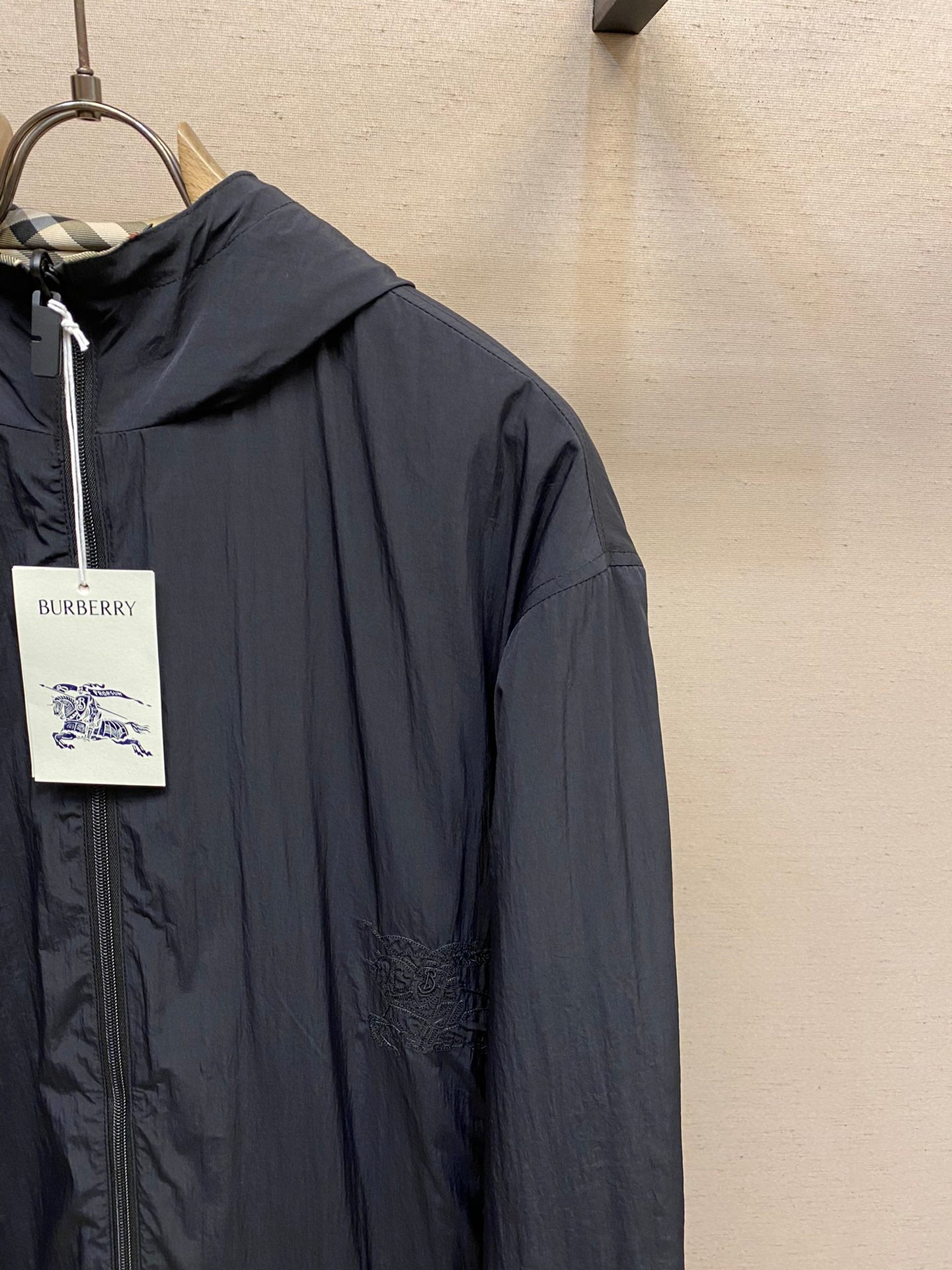 Dark navy hooded zip jacket with smooth fabric and seam details