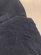 Navy jacket with ornate embroidered cross emblem on sleeve