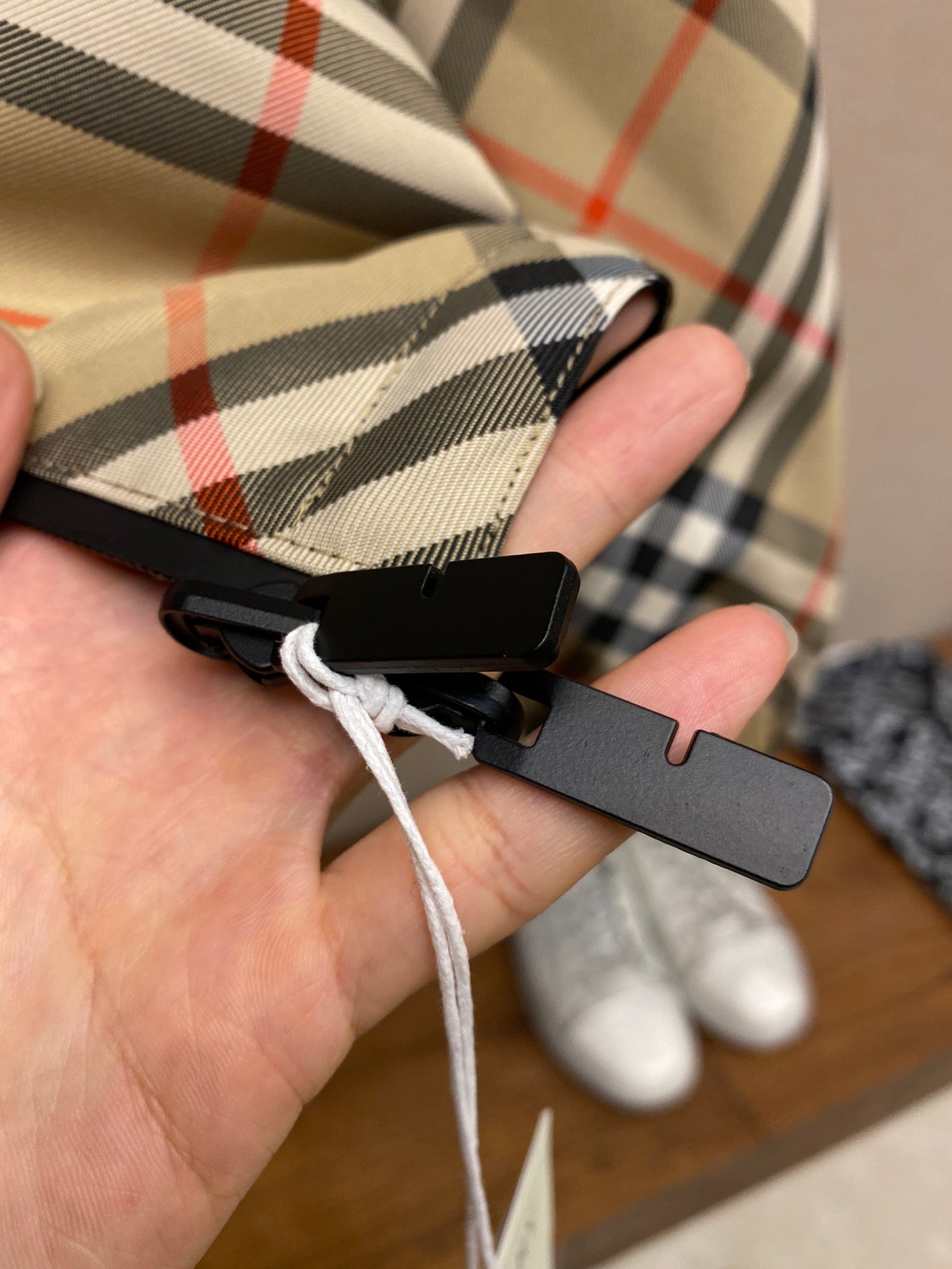 Plaid jacket drawstring with black toggle and white cord on hanger