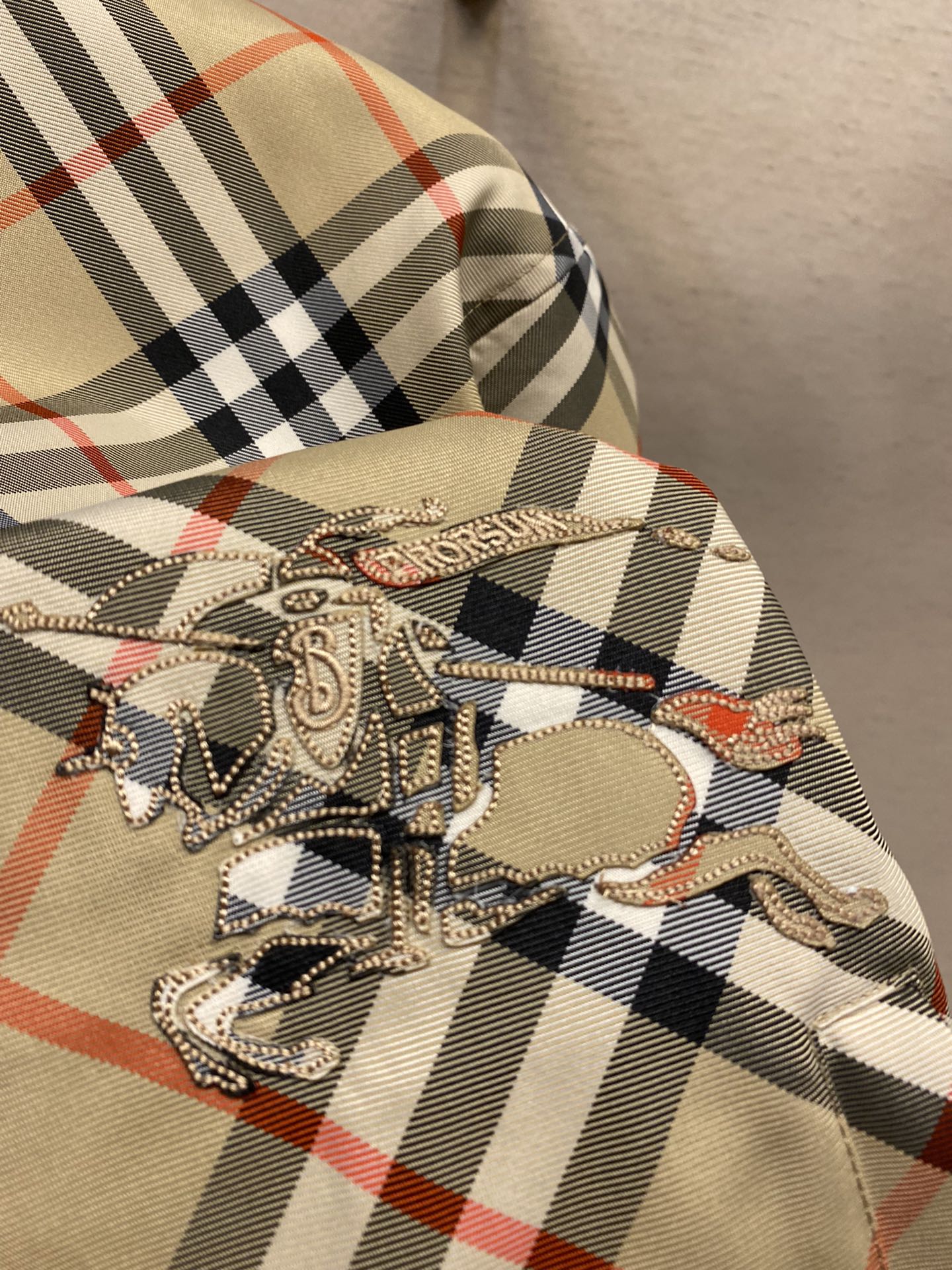 Beige plaid hooded jacket with large embroidered horse graphic on chest