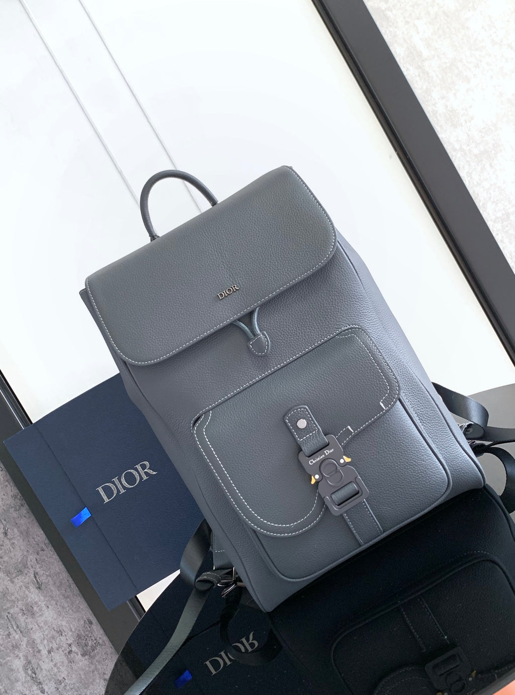 Men's gray leather backpack with front flap and buckle closure