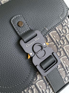 Dior bag close-up of gray leather key charm and Dior Oblique strap detail