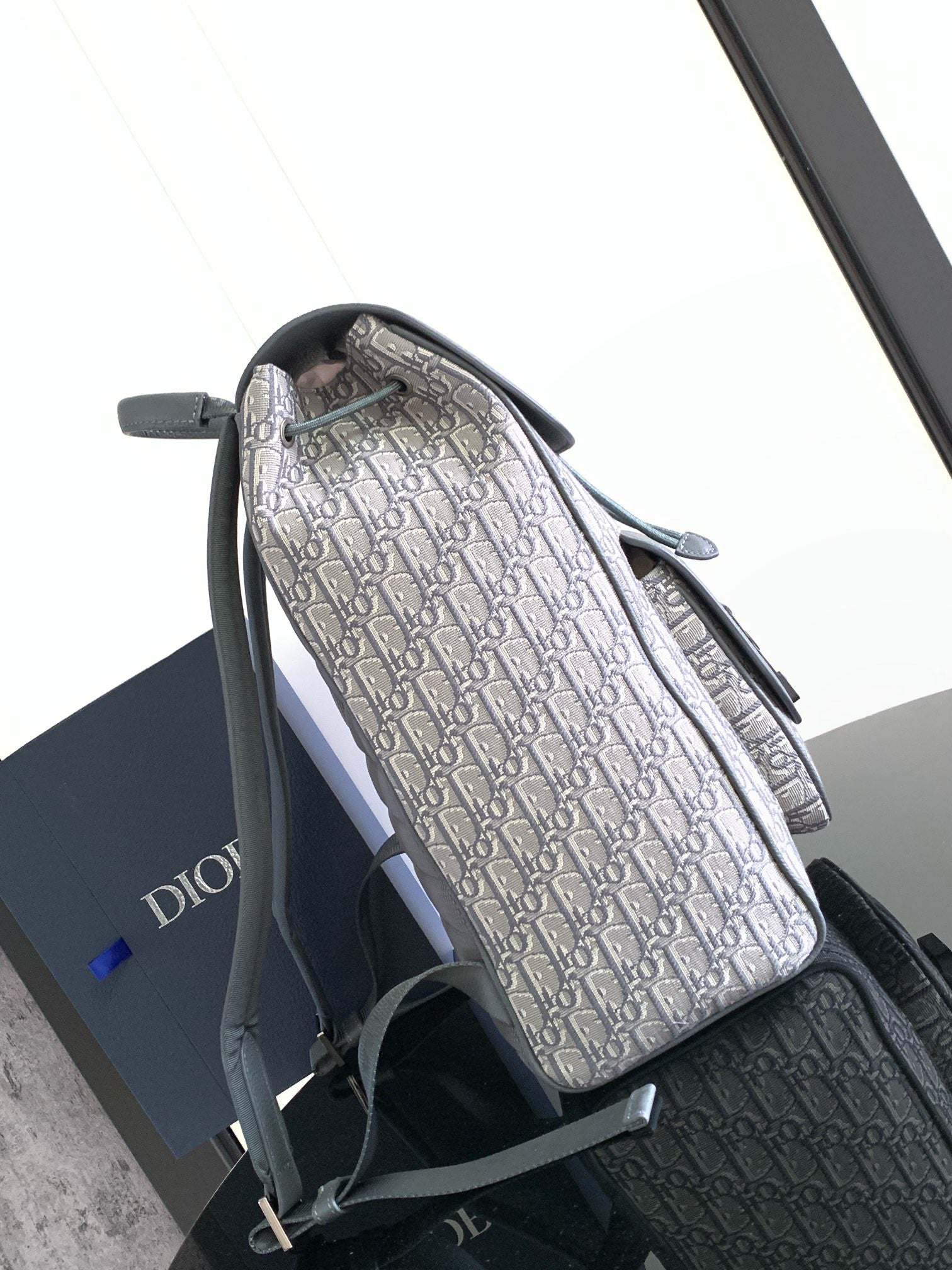 Dior bag with tall Dior Oblique print body, gray flap and adjustable shoulder strap