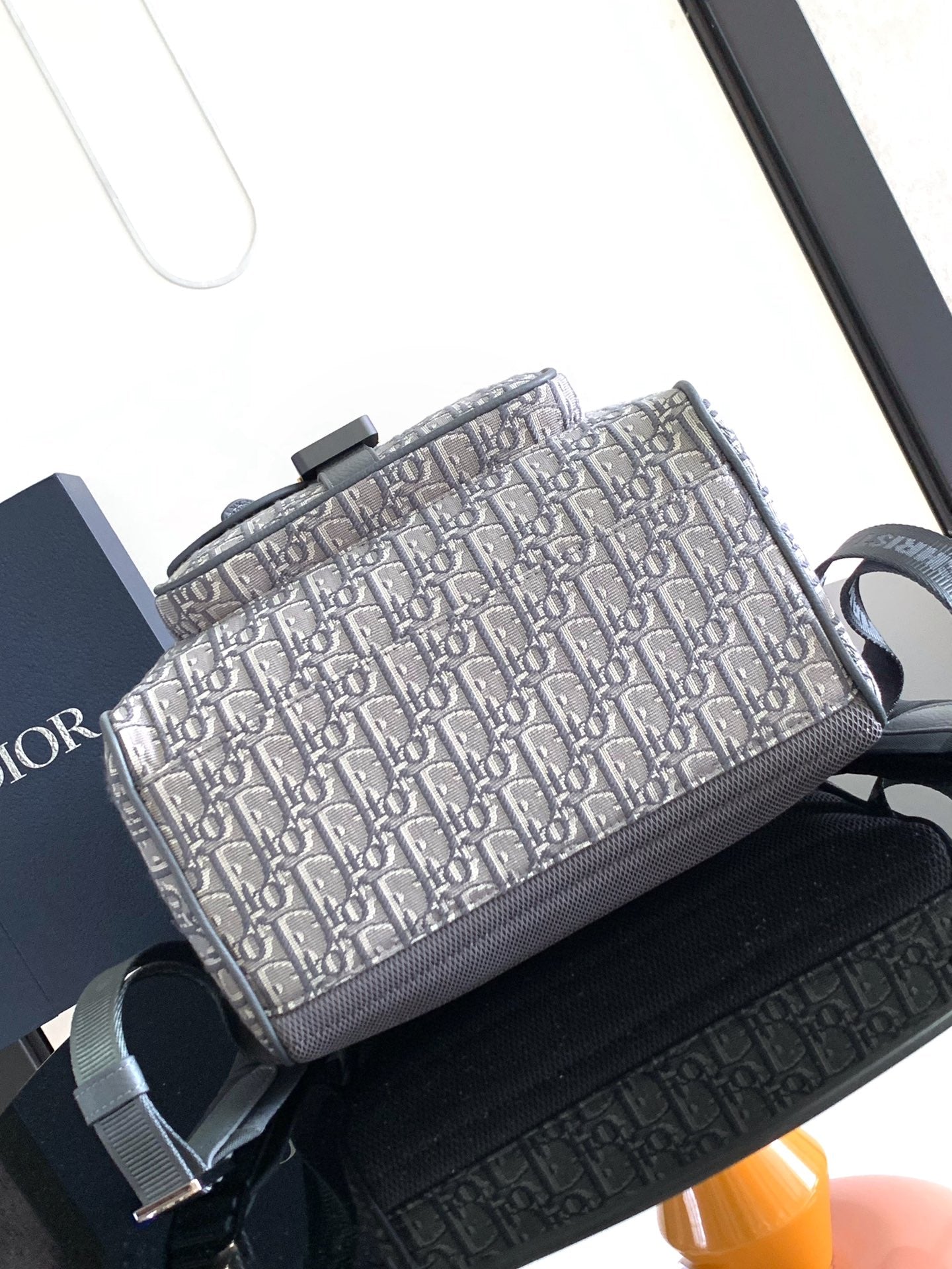Dior bag with Dior Oblique print front and gray leather top handle and strap