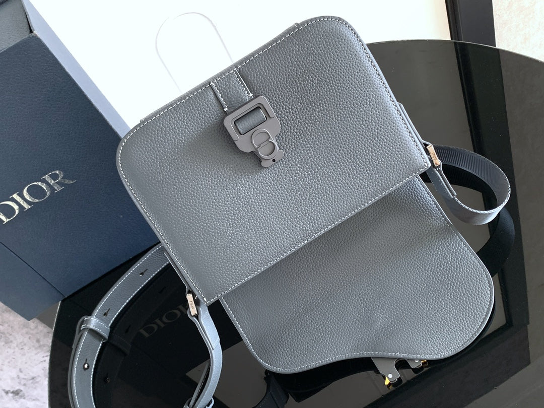 Blue-gray leather crossbody bag with flap front, buckle closure, and shoulder strap