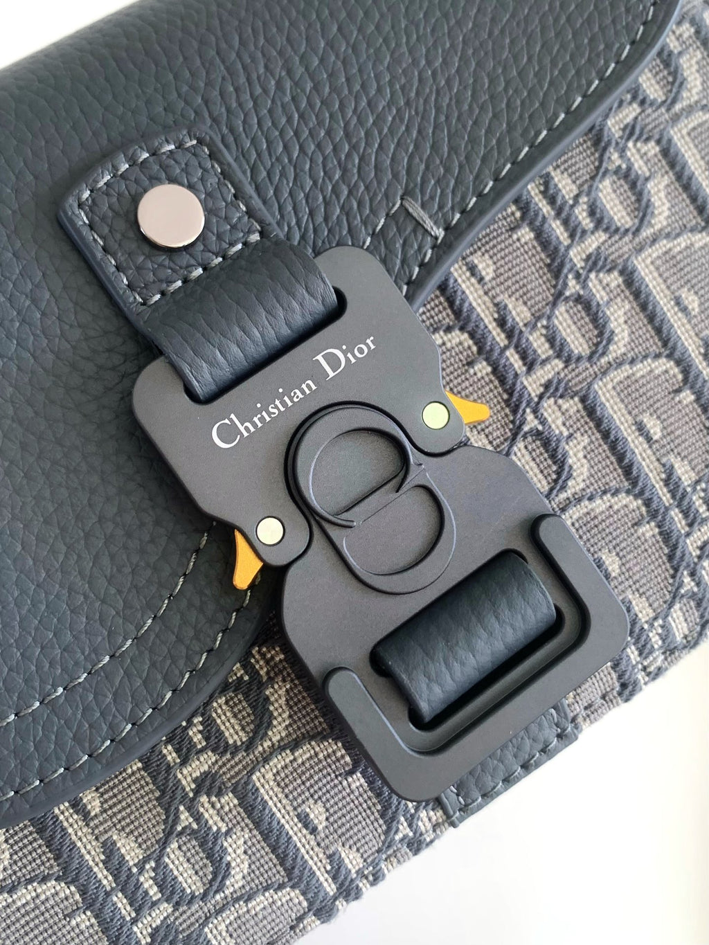 Blue-gray leather bag hardware with Dior charm and snap fastener detail