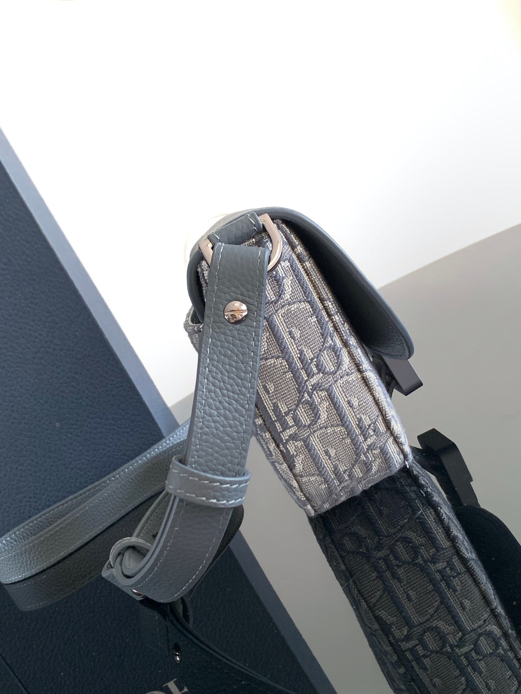Dior bag with gray leather strap and monogram canvas exterior, side view