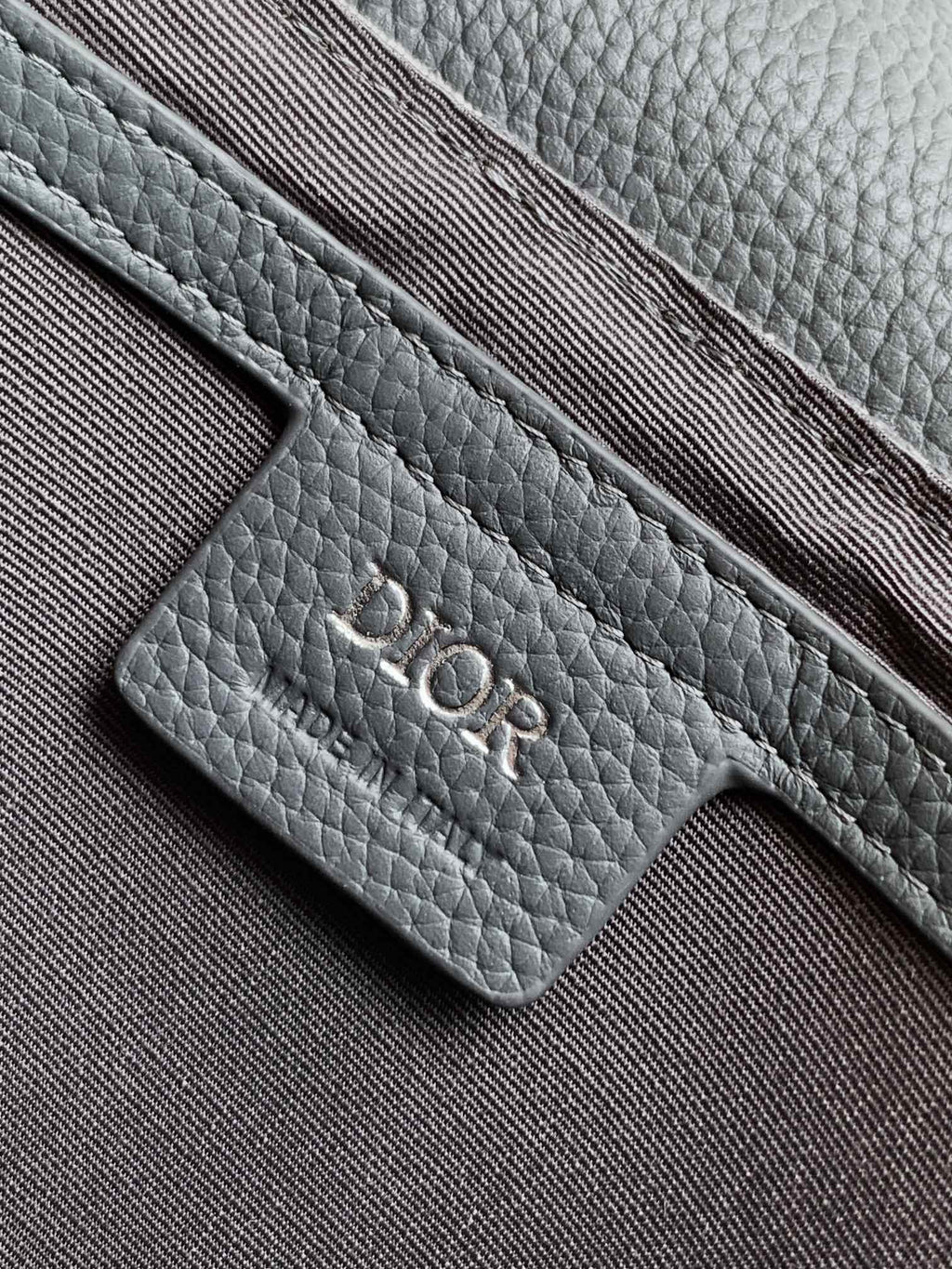 Dior bag close-up of gray leather card slot and stitched texture
