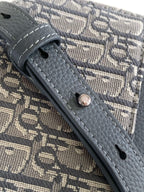 Dior bag close-up of gray leather strap attachment on monogram canvas