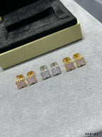 Four-leaf clover stud earrings set: gold and silver with pink enamel, laid out