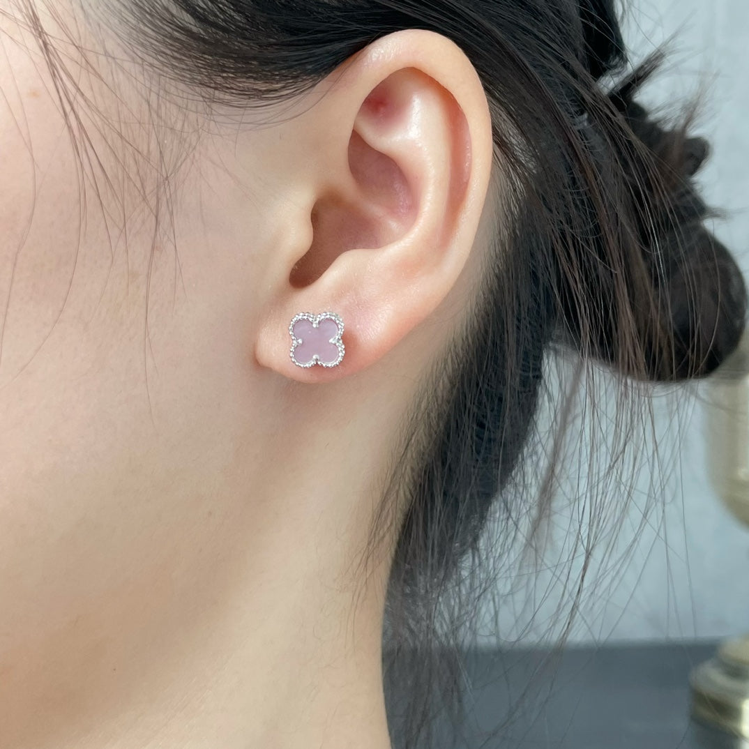 Four-leaf clover stud earring with pink enamel on the ear
